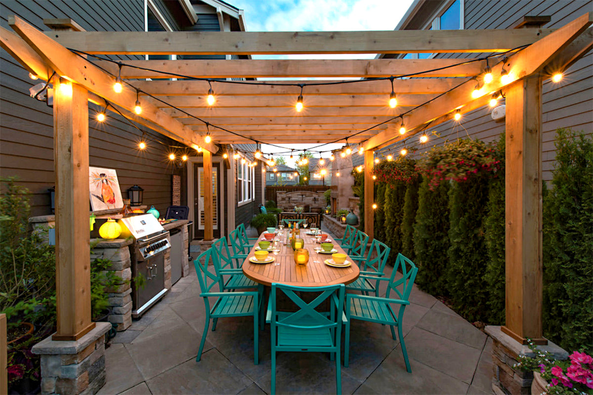 A cedar pergola with string lights over a patio and outdoor seating area