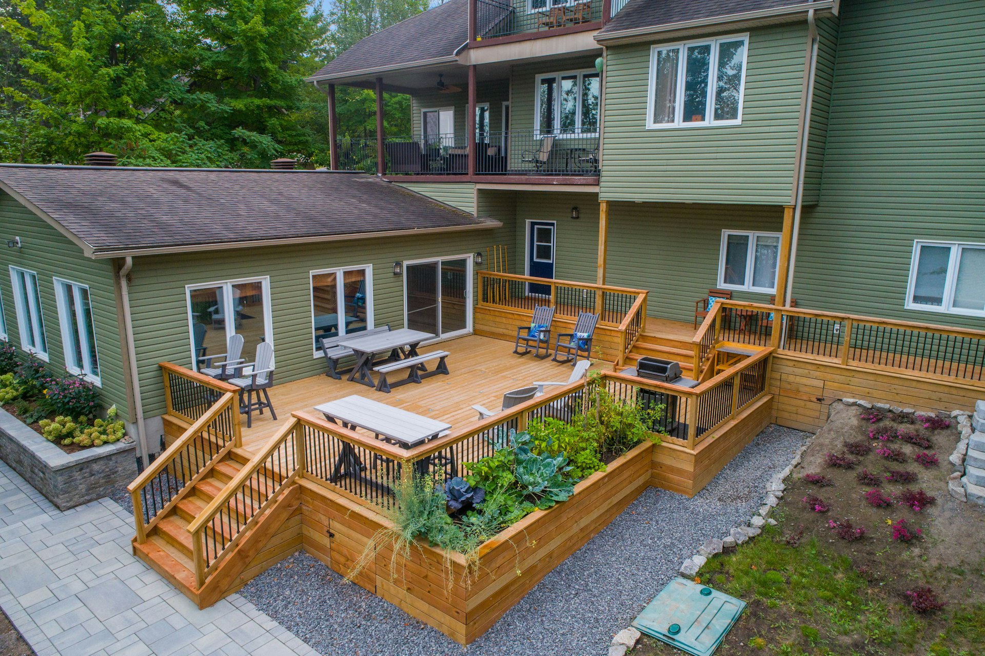 A multi-level cedar deck with railings, stairs, and built-in planters on a suburban home — the kind of custom deck AMM Construction Services builds across the Tulsa metro